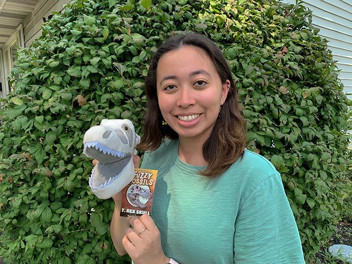 Woman holding Roaring T. rex plush