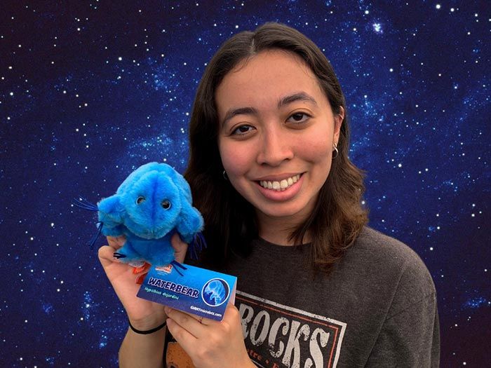 Waterbear plush in space with woman